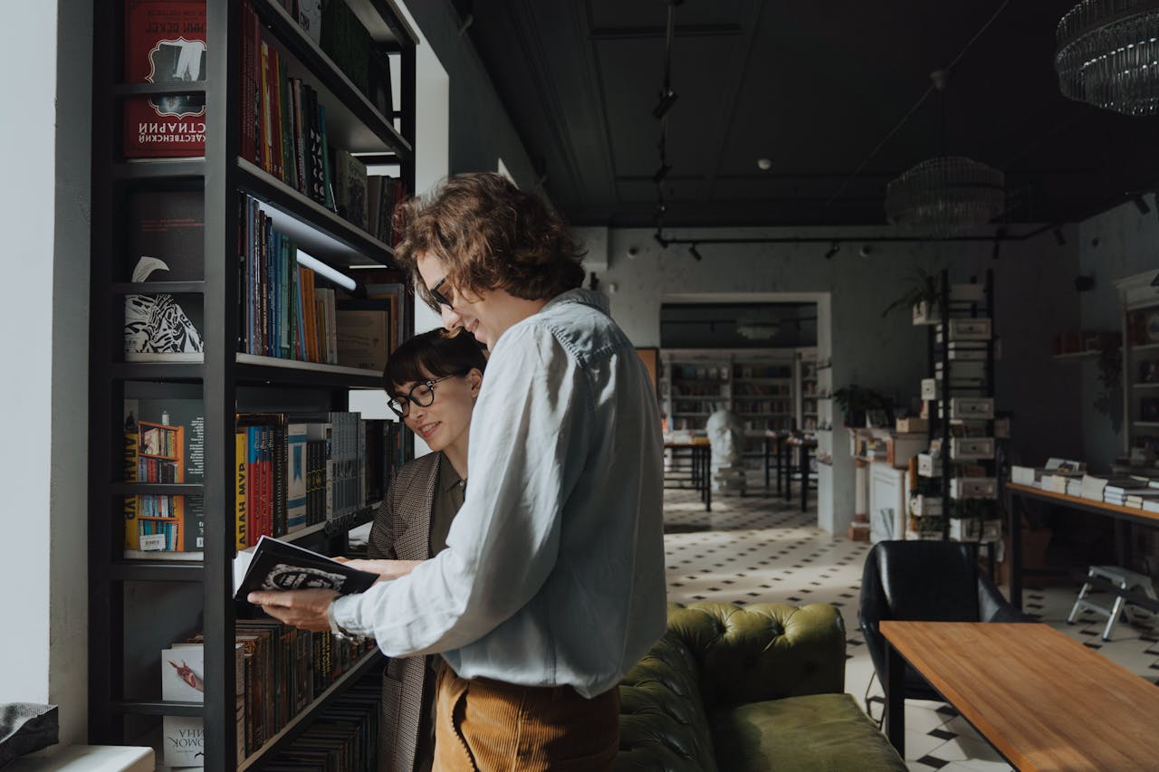 Mastering the First Impression: Your intriguing post title goes here Two adults browsing books in a stylish library, sharing joy and knowledge.